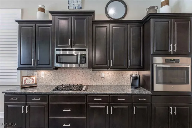 a kitchen with granite countertop wooden cabinets and stainless steel appliances