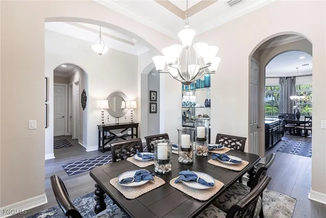 a view of a dining room with furniture a chandelier and wooden floor