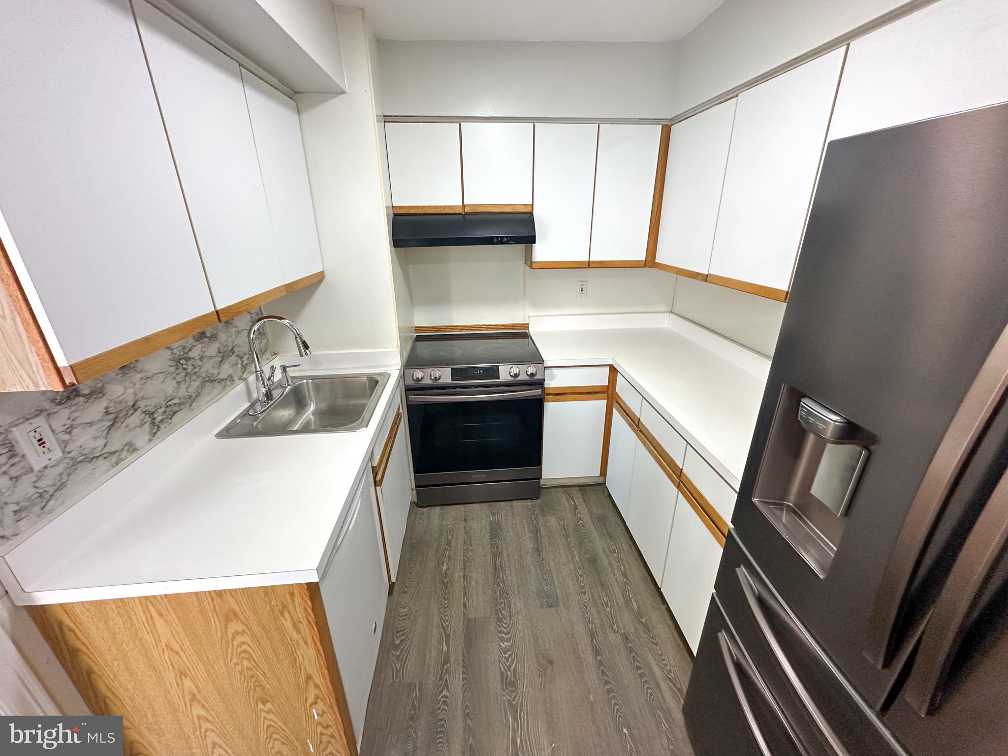 217 Stevens Street Philadelphia, PA 19111 - Photo 2 of 18 a kitchen with a sink a stove top oven and cabinets