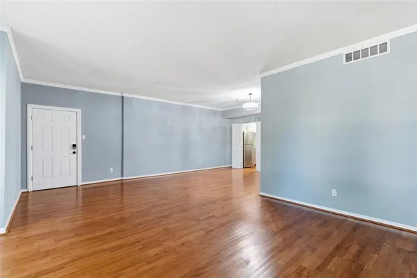 a view of an empty room with wooden floor