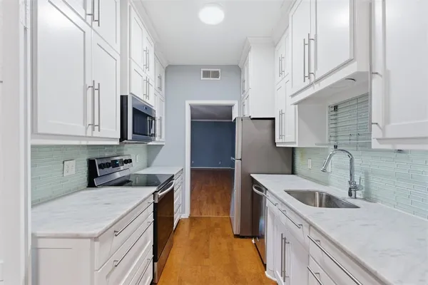 a kitchen with stainless steel appliances granite countertop a sink stove and refrigerator