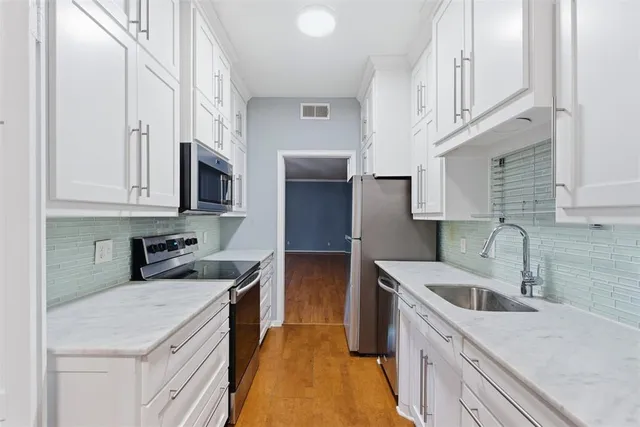 a kitchen with stainless steel appliances granite countertop a sink stove and refrigerator