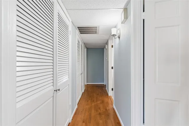 a view of a hallway with wooden floor