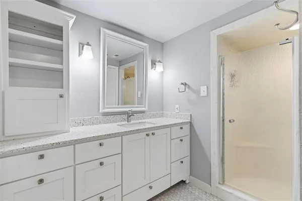 a bathroom with a granite countertop sink and a mirror