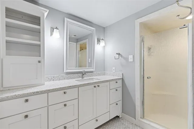 a bathroom with a granite countertop sink and a mirror