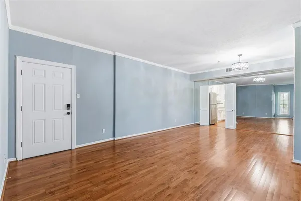 a view of an empty room with wooden floor