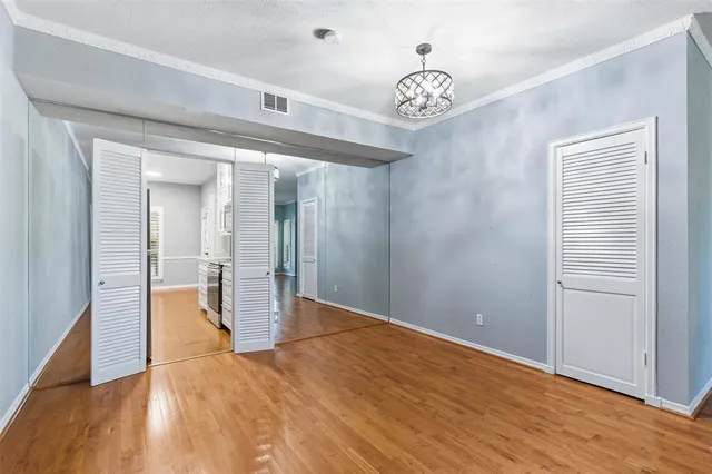 a view of a hallway with wooden floor and a chandelier