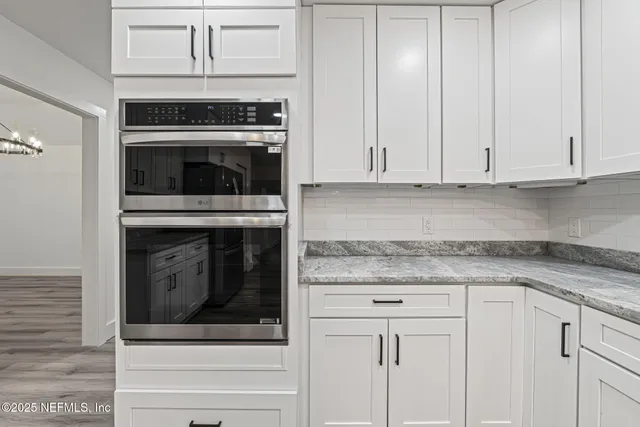 an empty room with wooden floor and natural light