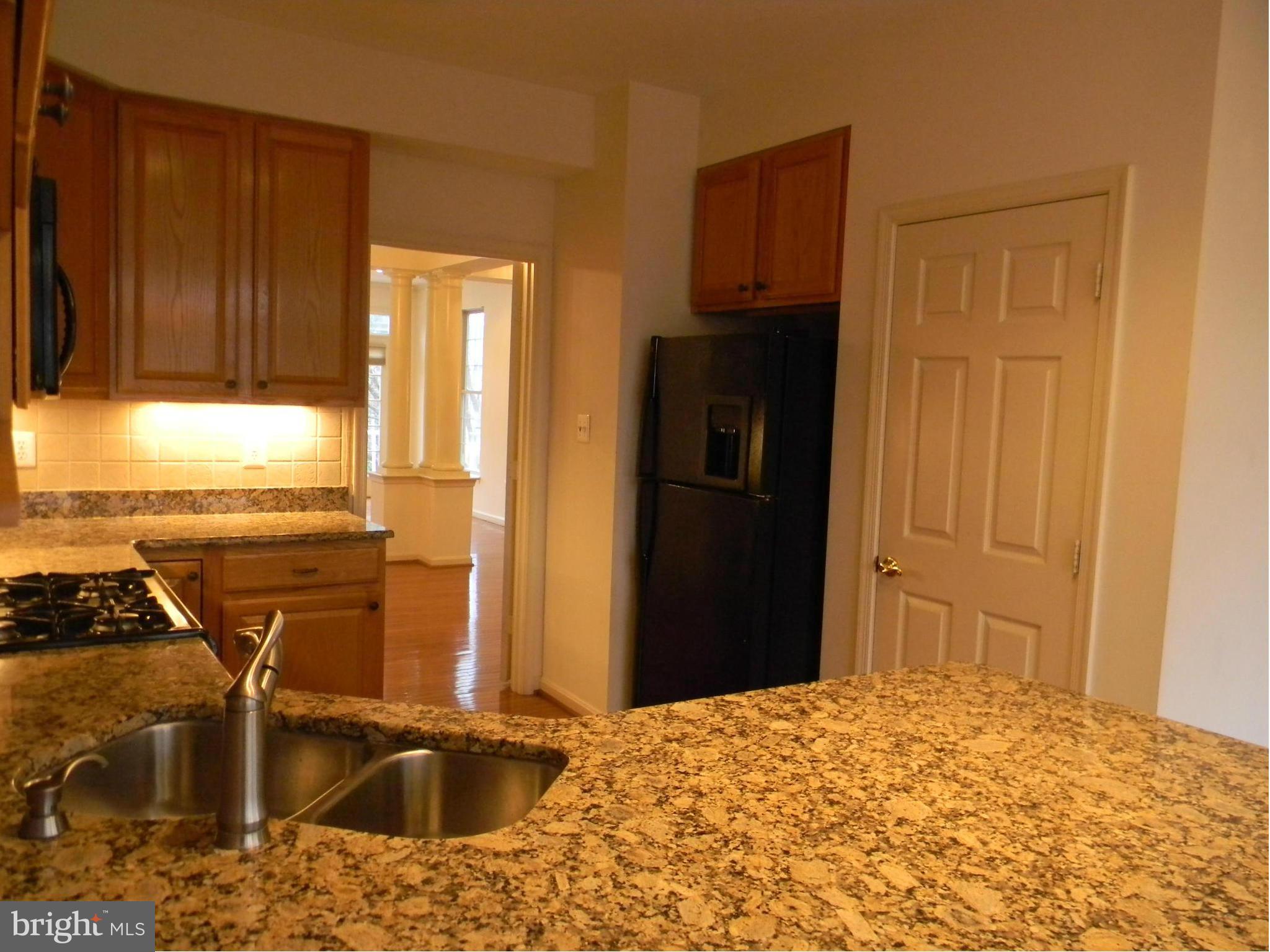 2442 Rippling Brook Road Frederick, MD 21701 - Photo 11 of 30 a kitchen with stainless steel appliances granite countertop a refrigerator a stove and a sink with wooden cabinets