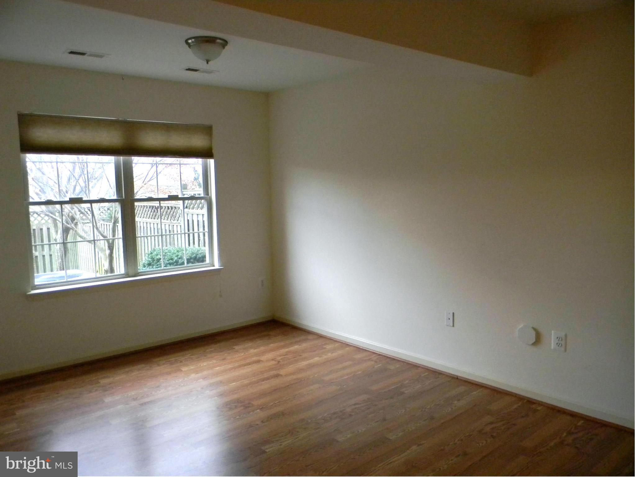 2442 Rippling Brook Road Frederick, MD 21701 - Photo 26 of 30 an empty room with wooden floor and windows