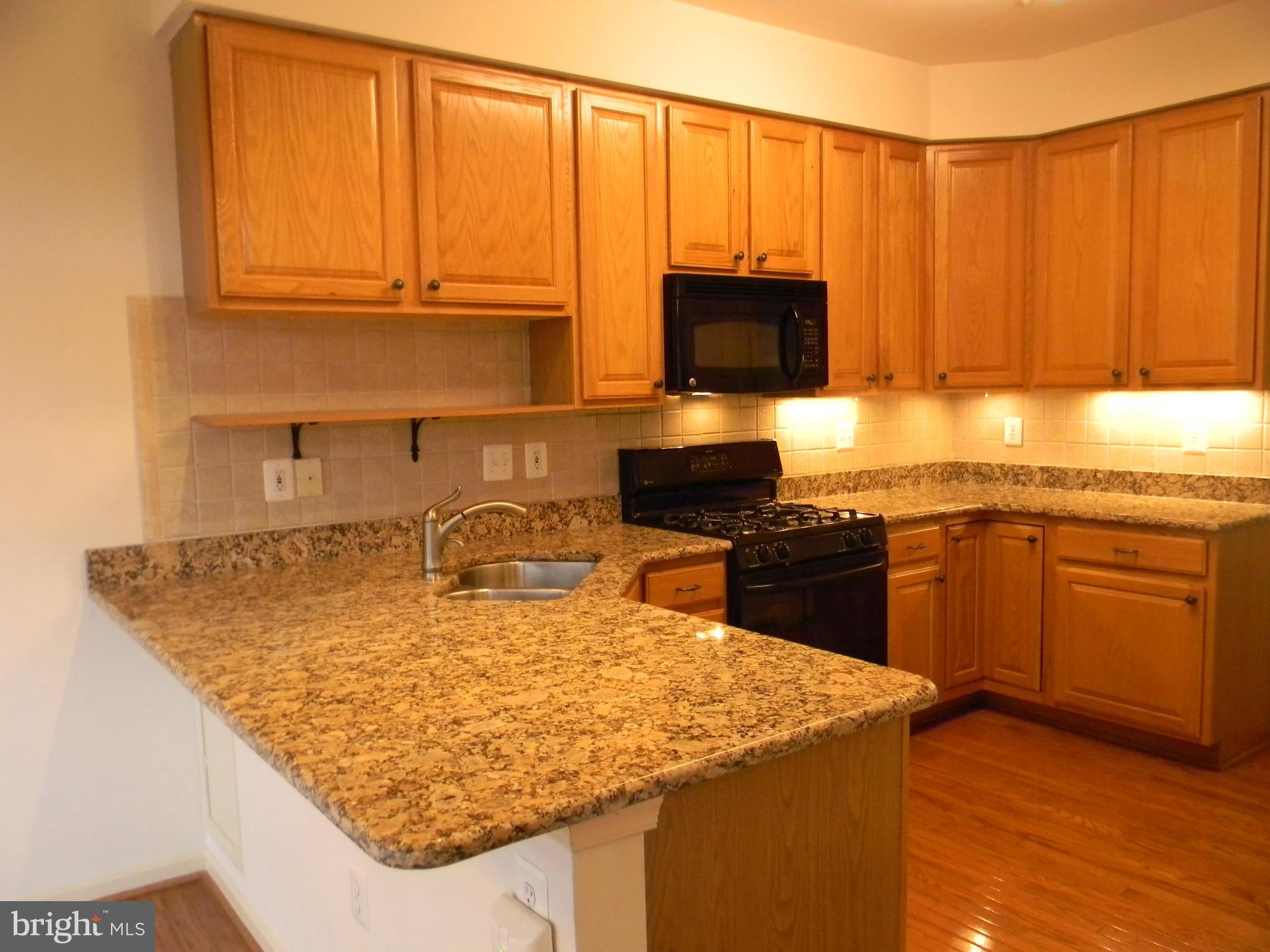 2442 Rippling Brook Road Frederick, MD 21701 - Photo 9 of 30 a kitchen with kitchen island granite countertop a sink a stove and cabinets