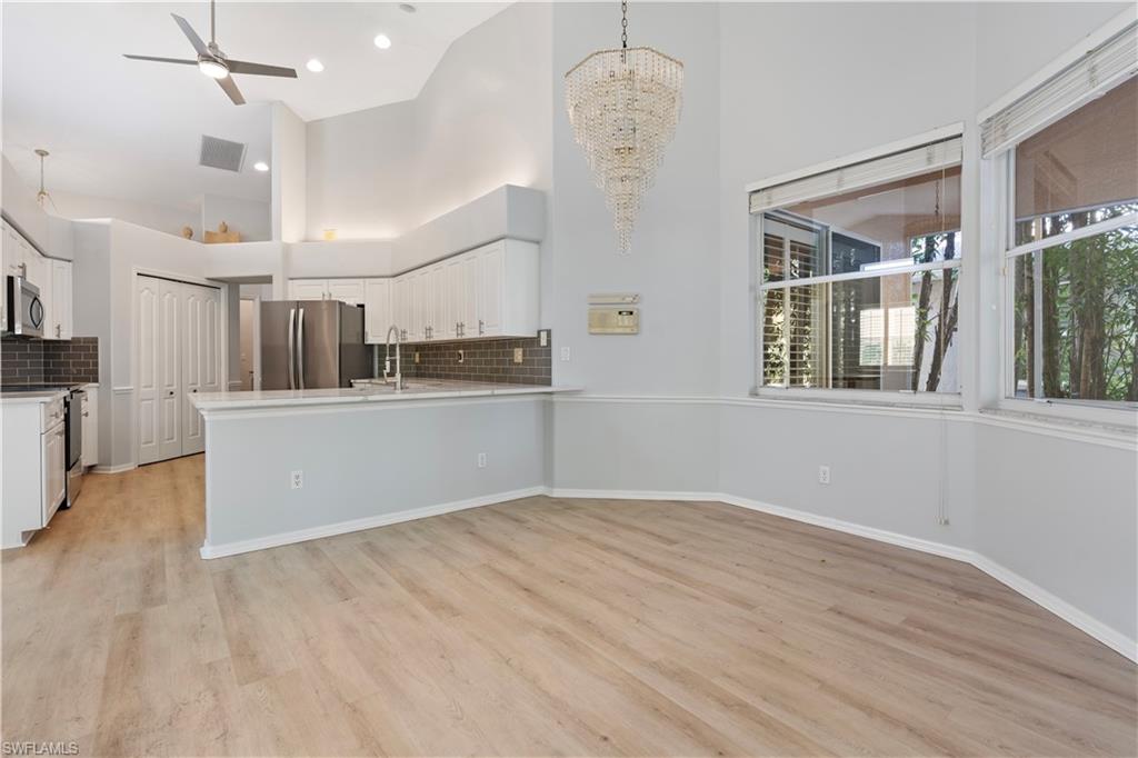 20751 Rivers Ford Estero, FL 33928 - Photo 23 of 36 Kitchen with white cabinetry, ceiling fan, appliances with stainless steel finishes, a high ceiling, and light wood-style flooring