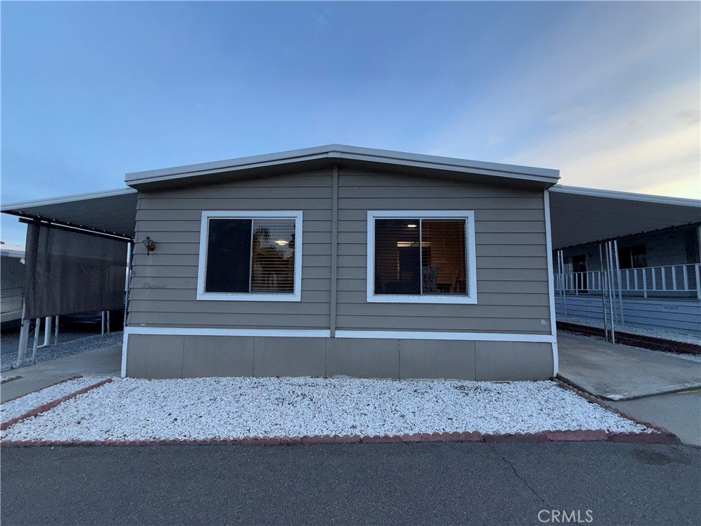 32600 State Highway 74, Unit 140 Hemet, CA 92545 - Photo 22 of 30 a front view of a house with a yard and garage
