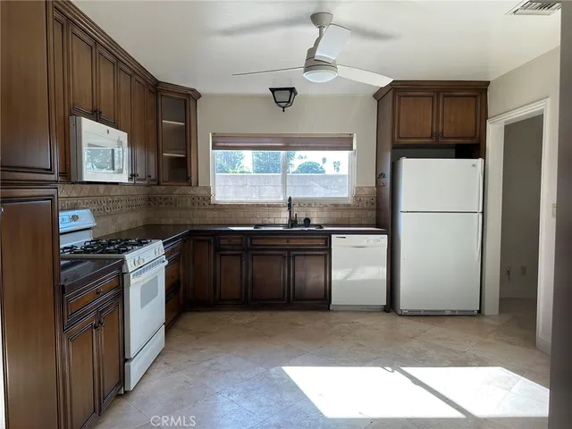 a kitchen with granite countertop stainless steel appliances and wooden cabinets