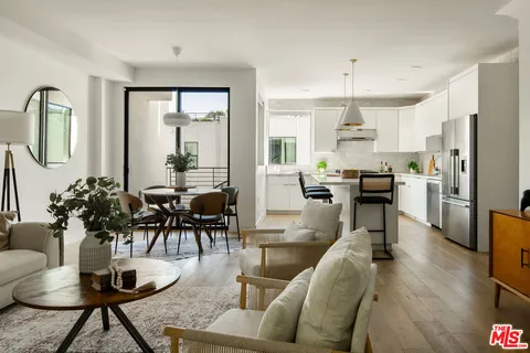 a living room with lots of furniture and kitchen view