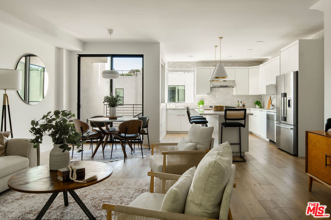 a living room with lots of furniture and kitchen view