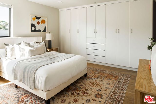 a bedroom with a bed and painting on the wall