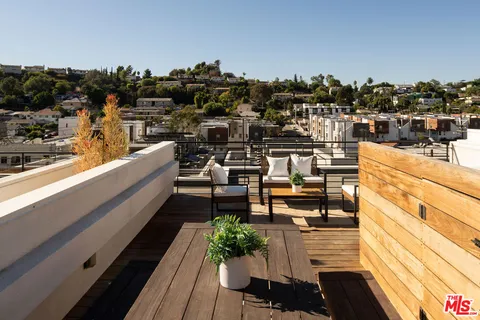 a view of a balcony with chairs and a potted plant