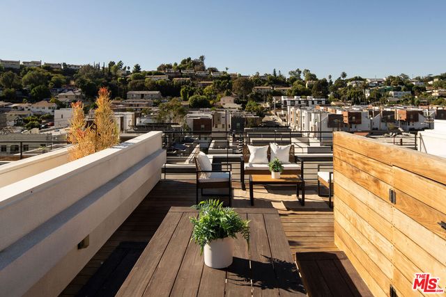 a view of a balcony with chairs and a potted plant