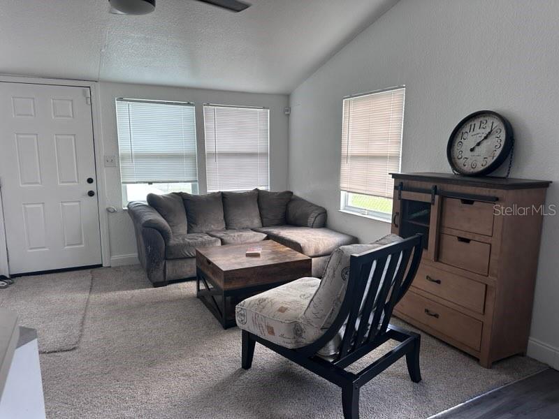 10030 Ingram Avenue Ocoee, FL 34761 - Photo 7 of 16 a living room with furniture a clock on wall and a window