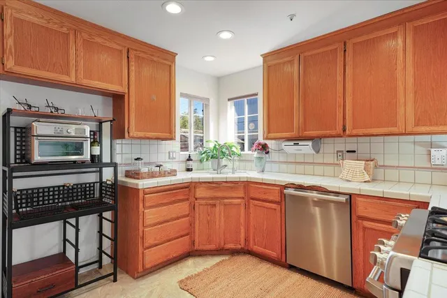 a kitchen with a sink cabinets appliances and a window
