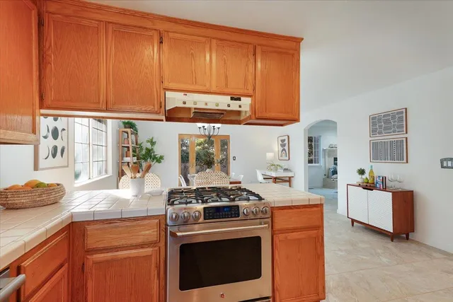 a kitchen with stainless steel appliances granite countertop a stove a sink and a microwave