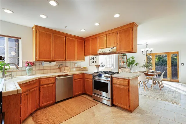 a kitchen with stainless steel appliances granite countertop wooden cabinets a sink and a stove