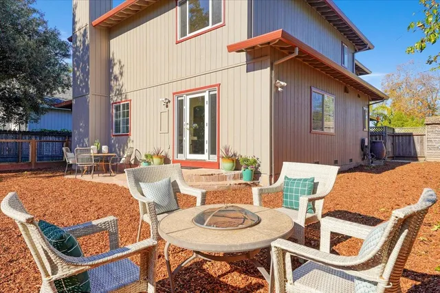a view of a patio with table and chairs and a barbeque