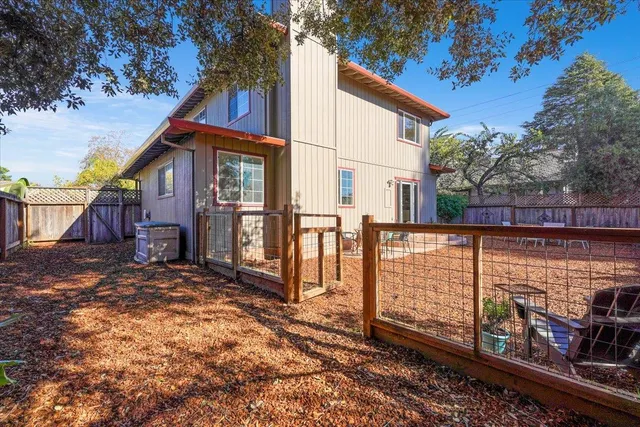 a view of a house with a yard and wooden fence