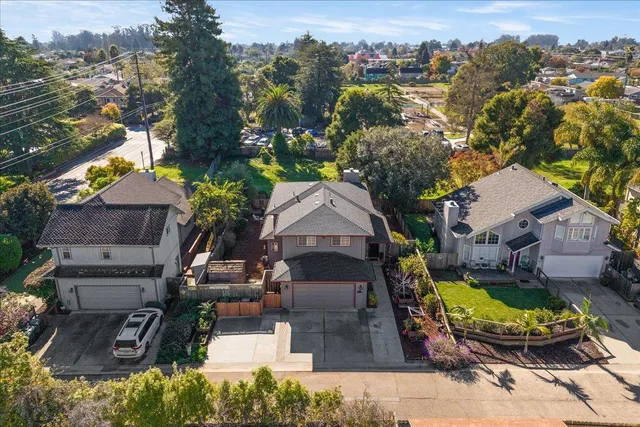 an aerial view of a house with a yard and lake view