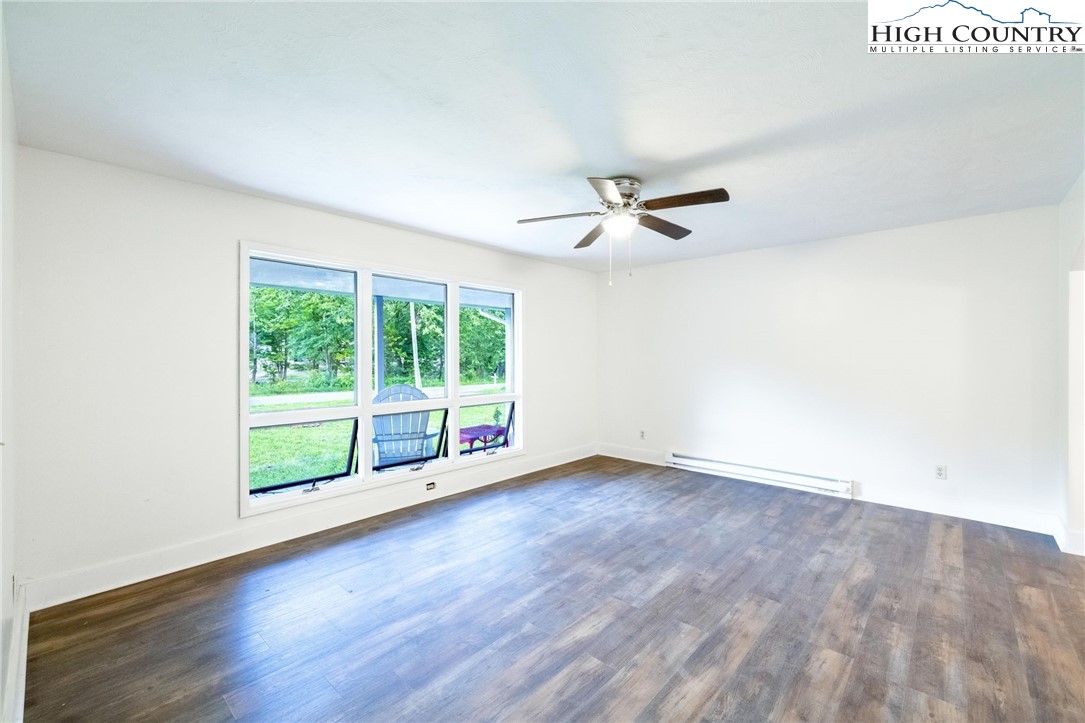 898 3 Top Road Creston, NC 28615 - Photo 11 of 48 an empty room with wooden floor and windows