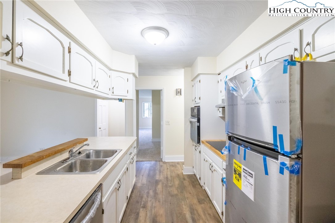 898 3 Top Road Creston, NC 28615 - Photo 19 of 48 a kitchen with granite countertop a sink a refrigerator a stove and cabinets