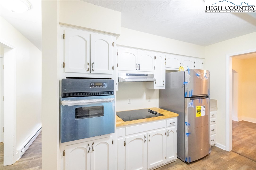 898 3 Top Road Creston, NC 28615 - Photo 22 of 48 a kitchen with a refrigerator sink stove and white cabinets