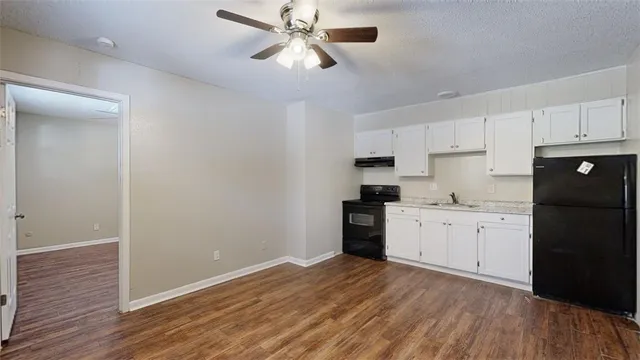 a kitchen with granite countertop white cabinets and stainless steel appliances