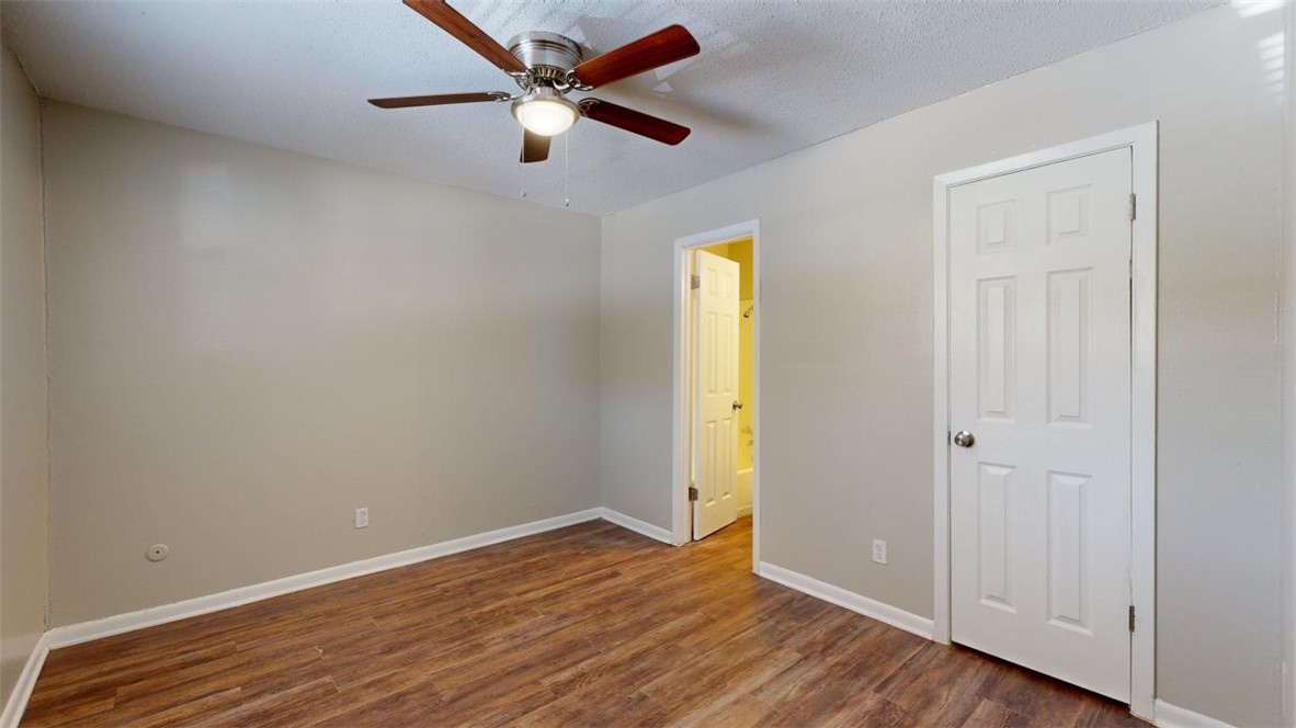 500 Foch Street, Unit 4 Bryan, TX 77801 - Photo 6 of 12 an empty room with wooden floor and a ceiling fan