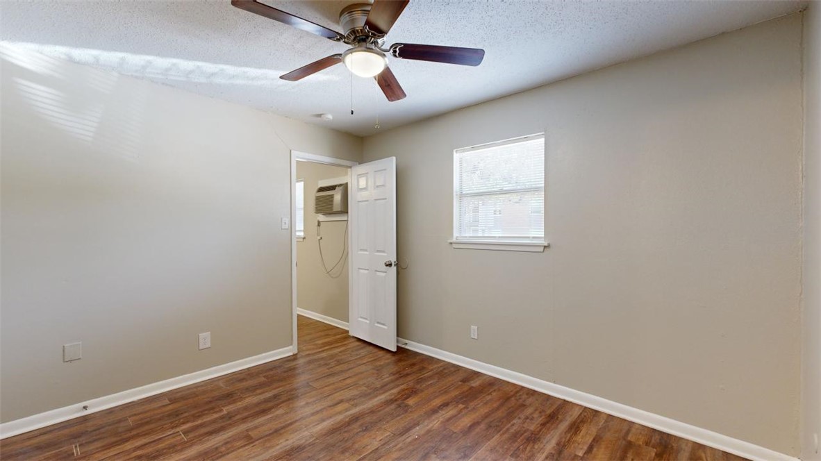 500 Foch Street, Unit 4 Bryan, TX 77801 - Photo 8 of 12 an empty room with wooden floor ceiling fan and windows