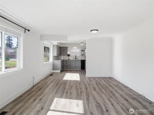 a view of a living room hardwood floor and a kitchen
