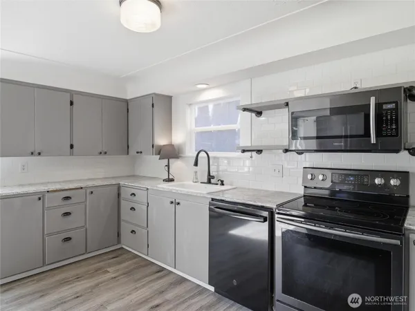 a kitchen with a sink stove and microwave