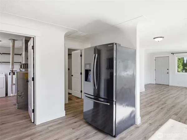 a kitchen with stainless steel appliances a refrigerator and wooden floor