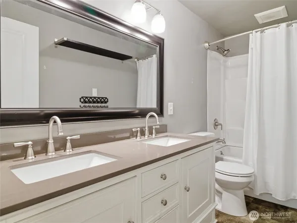 a bathroom with a granite countertop sink a toilet and a mirror