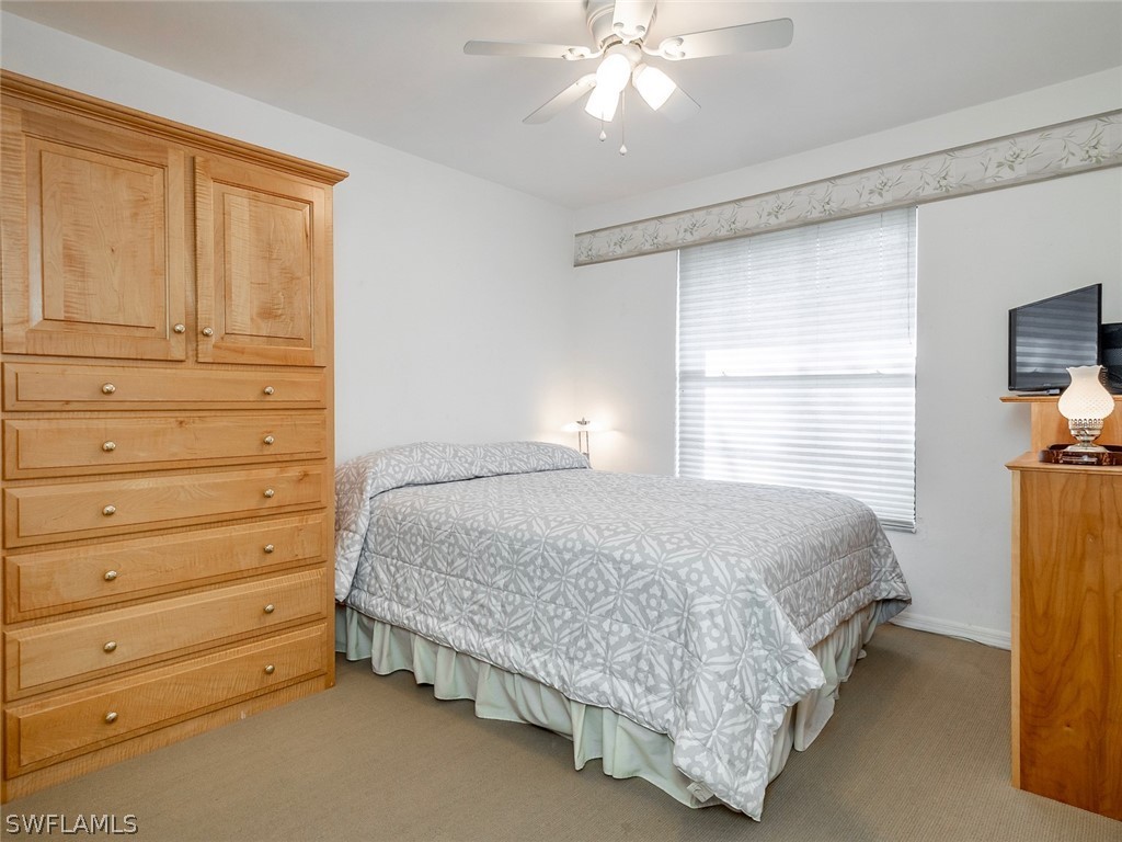 13166 Heather Ridge Loop Fort Myers, FL 33966 - Photo 23 of 31 a bedroom with a bed and a chandelier