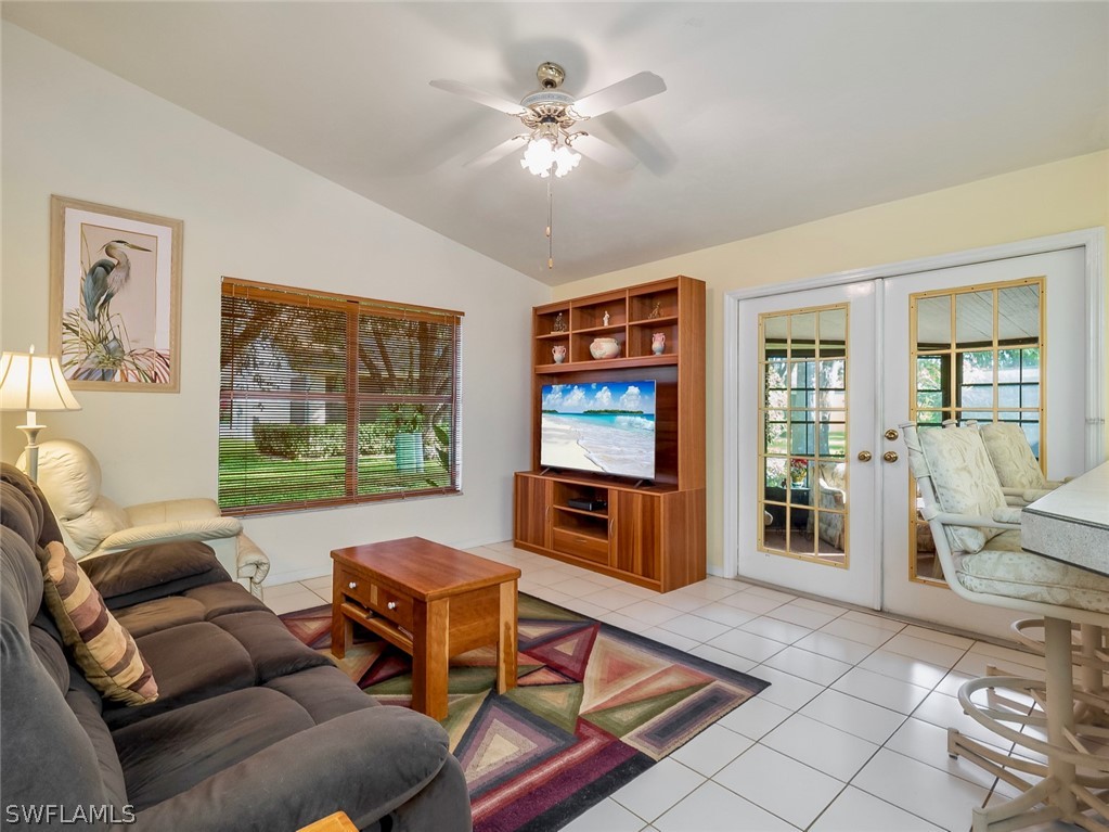 13166 Heather Ridge Loop Fort Myers, FL 33966 - Photo 4 of 31 a living room with furniture a flat screen tv and a floor to ceiling window