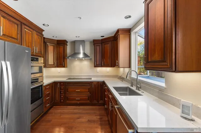 a kitchen with stainless steel appliances granite countertop a sink and a refrigerator