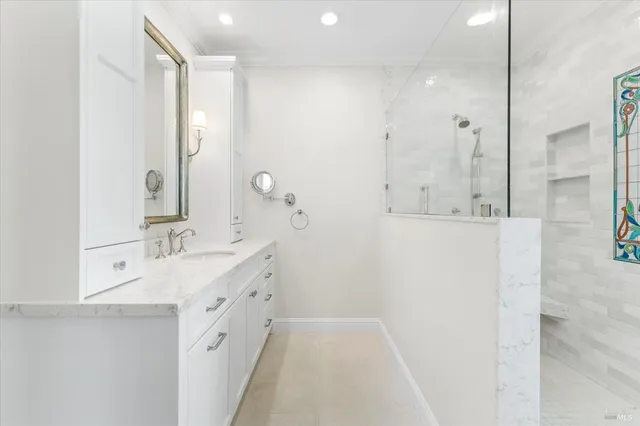 a bathroom with a double vanity sink mirror and shower