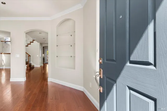 a view of a hallway with wooden floor and staircase