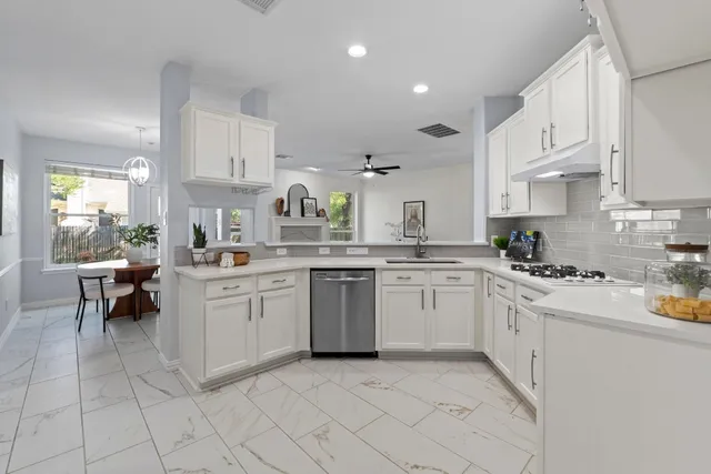 a kitchen with stainless steel appliances a refrigerator sink and cabinets