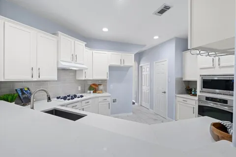 a view of empty room with wooden floor and ceiling fan
