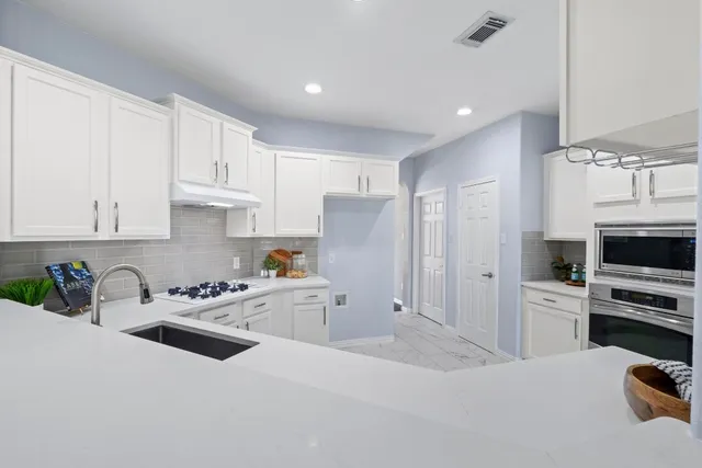 a view of empty room with wooden floor and ceiling fan