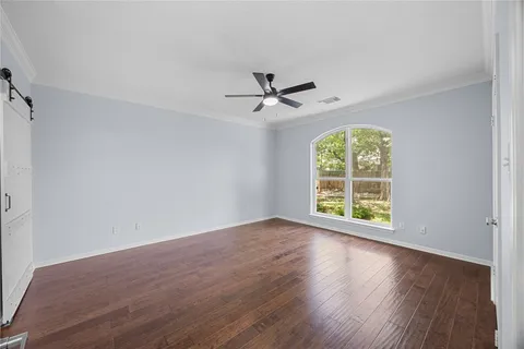 a view of an empty room with wooden floor