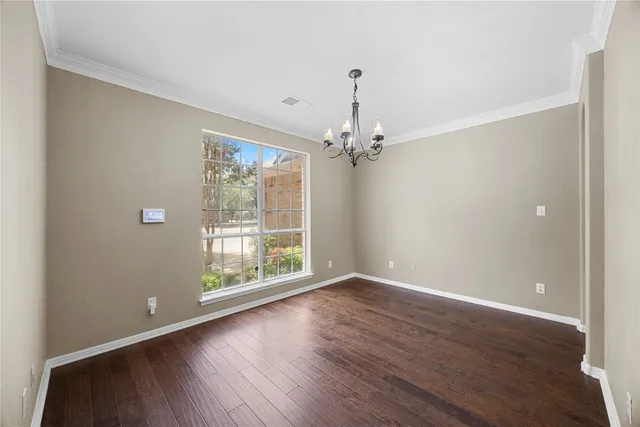 an empty room with windows and ceiling fan